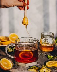 Close-up of hand pouring drink in glass