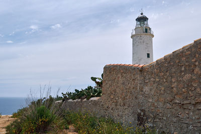 Lighthouse by sea against sky