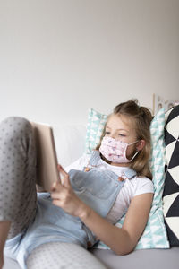 Girl using mobile phone on sofa at home