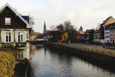 River amidst houses in town against sky