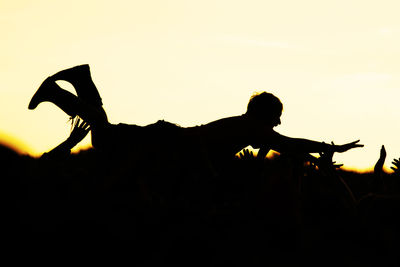 Silhouette man against clear sky during sunset