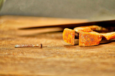 Close-up of old rusty metal screw on table