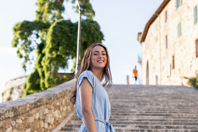 Portrait of smiling young woman standing outdoors