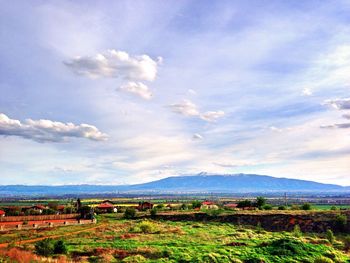 Scenic view of field against cloudy sky