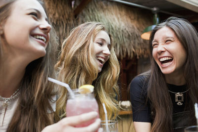 Happy young friends enjoying drinks at a bar