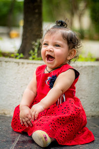 Portrait of cute girl sitting outdoors