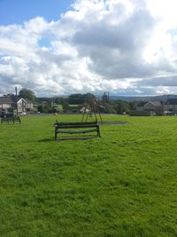 View of grassy field against cloudy sky