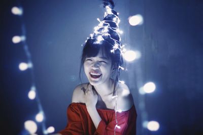 Portrait of young woman in illuminated light