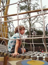 Low angle view of girl playing on field against trees