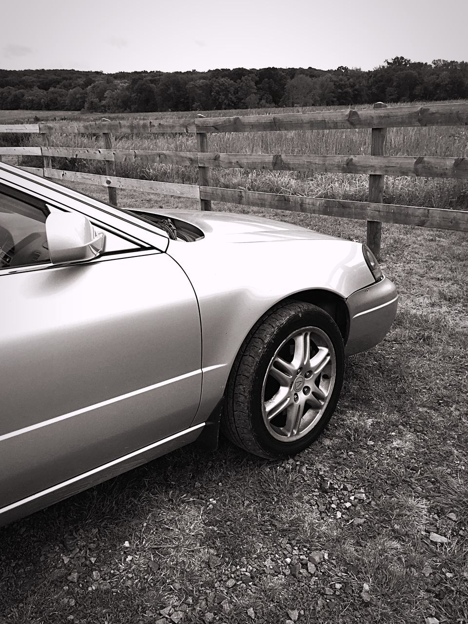 transportation, land vehicle, mode of transport, car, road, sky, landscape, clear sky, side-view mirror, wheel, street, stationary, travel, day, outdoors, sunlight, no people, tire, field, part of