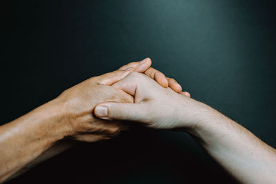 Close-up of man hand against black background