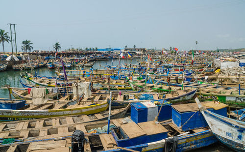 Boats moored at harbor against clear sky