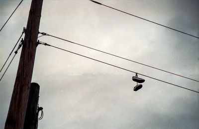 Low angle view of overhead cable car against sky