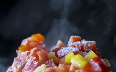 Chopped red and yeallow peppers on black background with flame