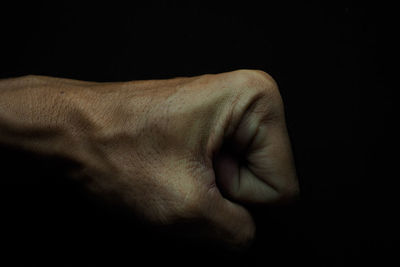 Close-up of human hand against black background