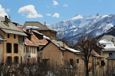 Houses and buildings against sky during winter