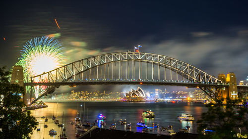 View of illuminated bridge over river at night