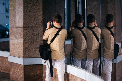 Rear view of people standing against building