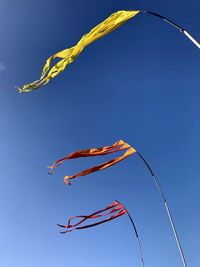 Low angle view of flag against clear blue sky