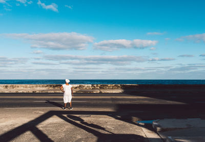 Man looking at sea shore against sky