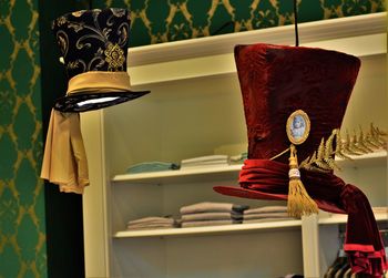 Hats hanging against shelf at home