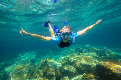 Portrait of young woman swimming in sea