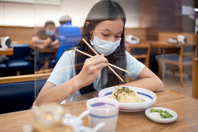 Girl eating food in restaurant