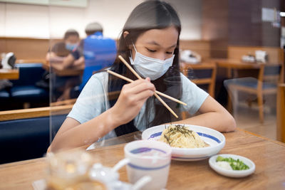 Midsection of woman holding ice cream in restaurant