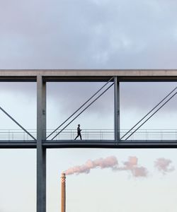 Low angle view of man walking on bridge