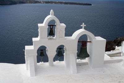 High section of bell tower against calm sea