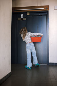 Rear view of young woman standing at home