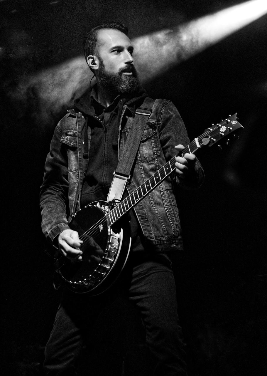 YOUNG MAN PLAYING GUITAR ON STAGE