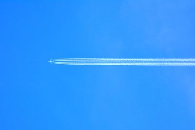 Low angle view of airplane flying against blue sky