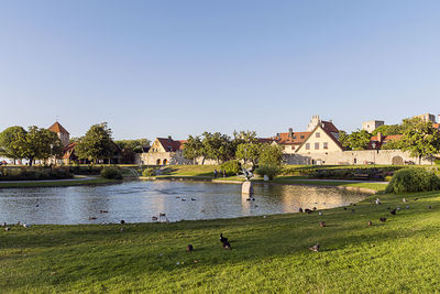 View of house by river against clear sky