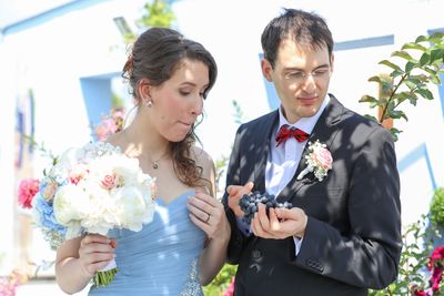 Couple with bouquet and fruits in wedding ceremony