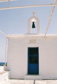 White bell tower against blue sky