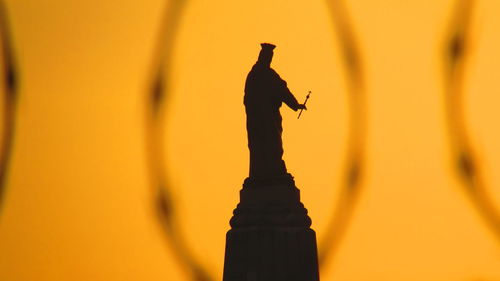 Silhouette of statue at sunset