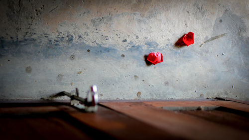 Close-up of red umbrella on floor against wall