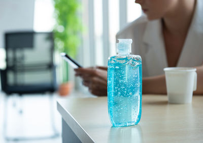 Close-up of woman holding camera on table