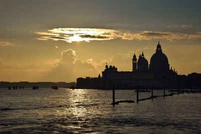 Silhouette of building against cloudy sky