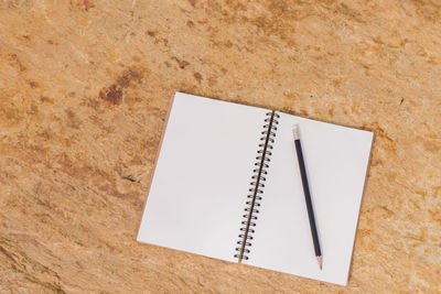 Close-up of notepad and pencil on table