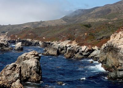Scenic view of sea and mountains against sky