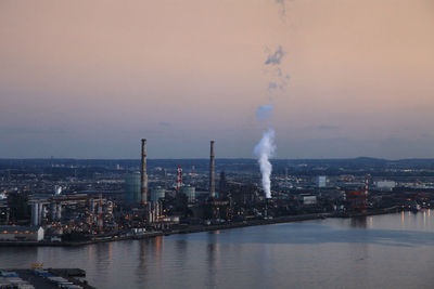 Smoke emitting from river against sky