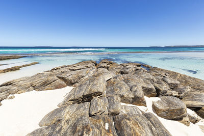 Scenic view of beach against clear blue sky