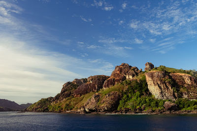 Rock formations by sea against sky