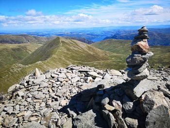 Stack of rocks on helvellyn summit with landscape against sky