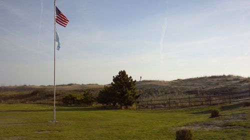 Flag on field against sky