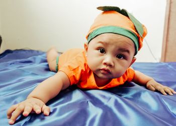 Portrait of cute boy lying on bed