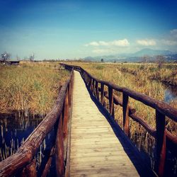 Boardwalk amidst sea against sky