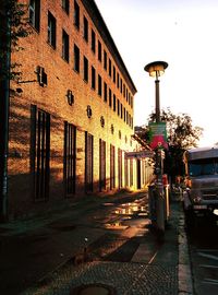 Illuminated street light in city against sky at night